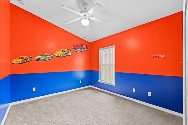 carpeted empty room featuring ceiling fan and lofted ceiling