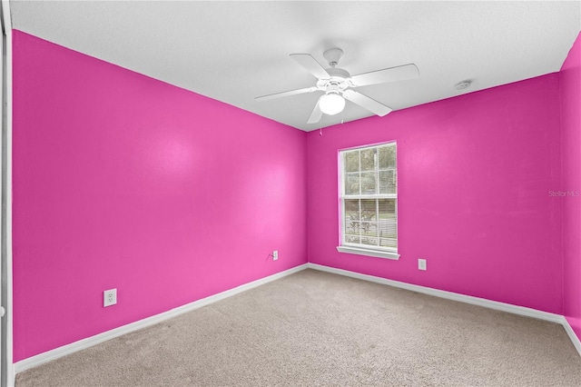 carpeted spare room with ceiling fan