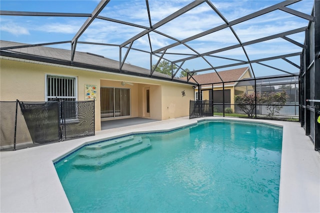 view of pool featuring glass enclosure and a patio area