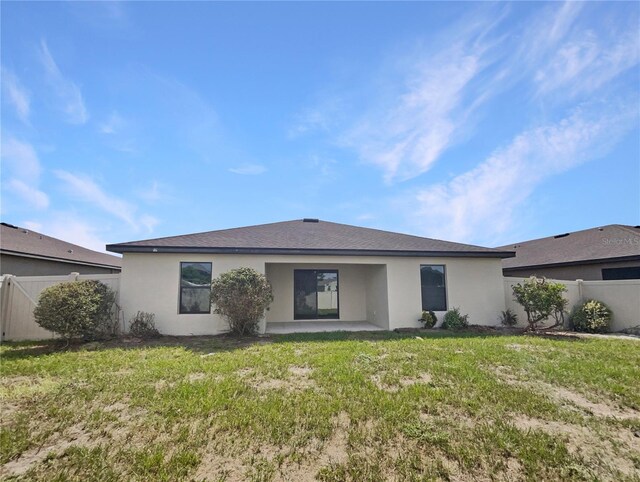 rear view of property featuring a patio area and a yard