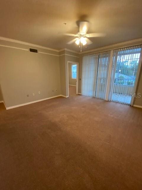 empty room with ceiling fan, carpet floors, and crown molding