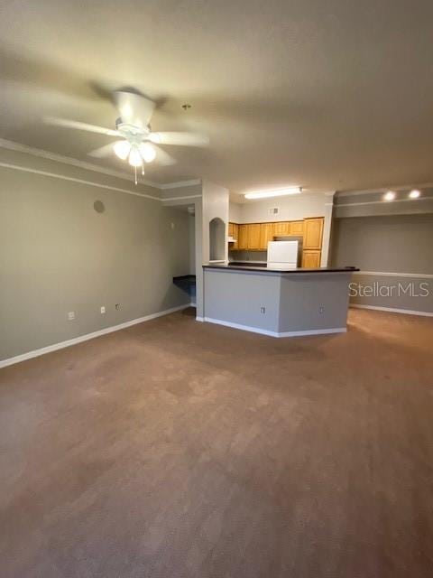 unfurnished living room with carpet flooring, ceiling fan, and crown molding