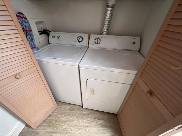 laundry area featuring washer and dryer and light tile patterned floors