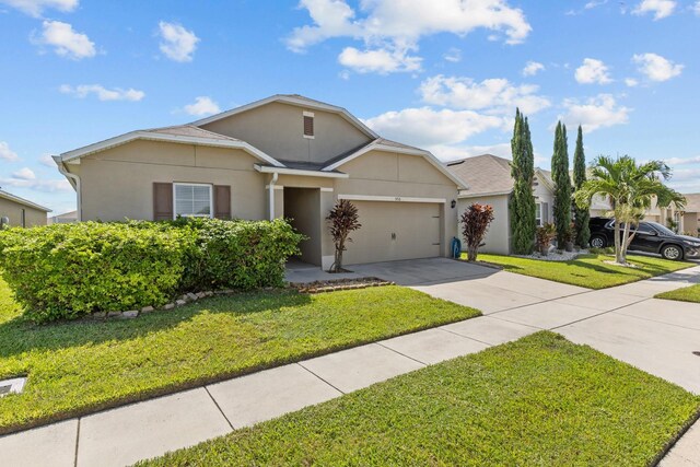 view of front of property featuring stucco siding, an attached garage, concrete driveway, and a front yard