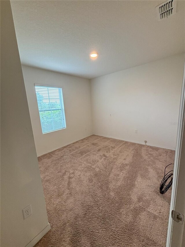 carpeted empty room with visible vents and recessed lighting