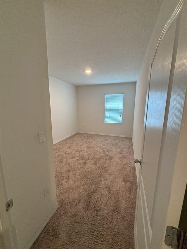 carpeted empty room with baseboards