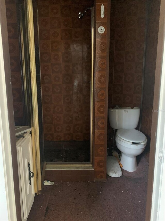 bathroom with an enclosed shower and toilet