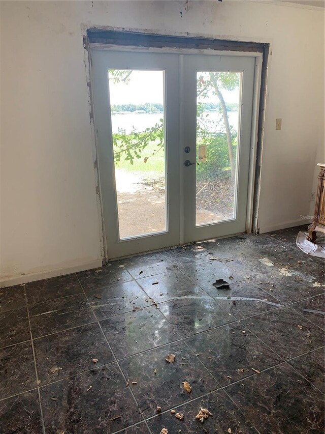 interior space with dark tile patterned flooring, plenty of natural light, and french doors