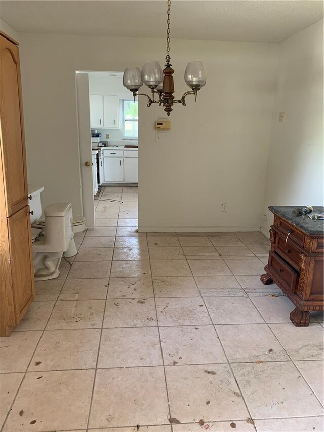 unfurnished dining area with a chandelier and light tile patterned floors