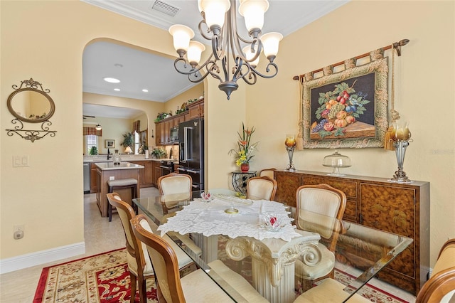 dining area with light tile patterned floors, a chandelier, and ornamental molding