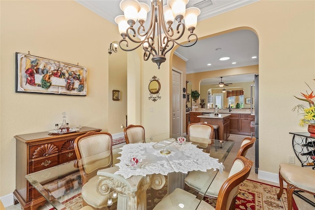 dining space with ceiling fan with notable chandelier and crown molding