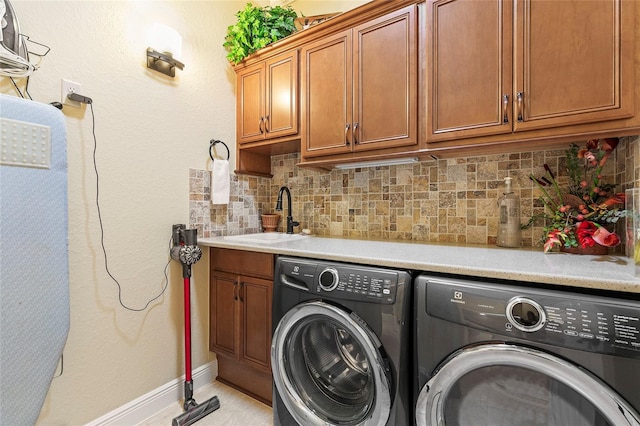 laundry area with cabinets, independent washer and dryer, and sink