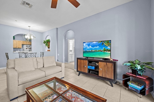 living room with ceiling fan with notable chandelier and light tile patterned floors