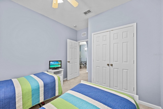 carpeted bedroom with ceiling fan and a closet