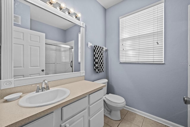 bathroom featuring tile patterned floors, vanity, walk in shower, and toilet