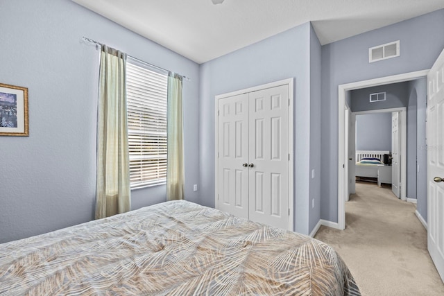 bedroom featuring light colored carpet and a closet