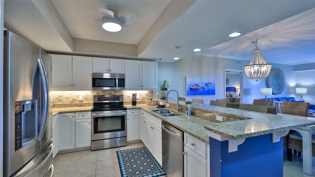 5300 S Atlantic Ave Unit 16-602, New Smyrna Beach, FL 32169 - kitchen featuring appliances with stainless steel finishes, a sink, a peninsula, open floor plan, and a chandelier