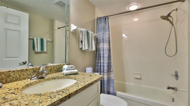 full bathroom featuring shower / bath combo, toilet, a textured ceiling, and vanity