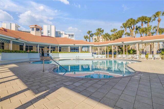 view of swimming pool featuring a hot tub and a patio area