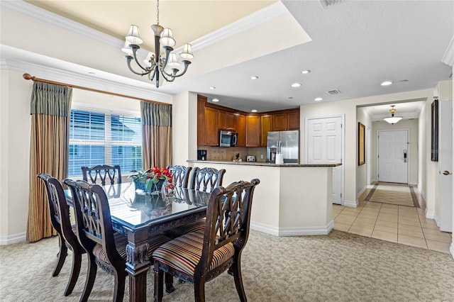 carpeted dining room featuring ornamental molding, a raised ceiling, and a notable chandelier