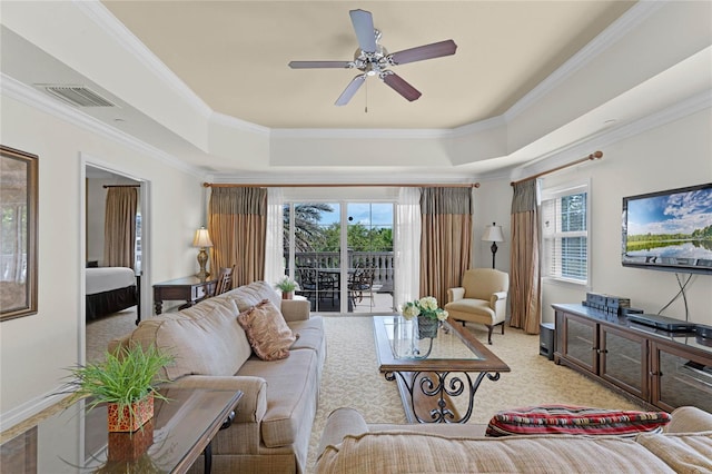 carpeted living room featuring crown molding, a raised ceiling, and ceiling fan