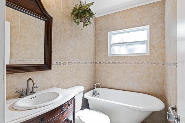 bathroom with tile walls, toilet, a bath, and vanity