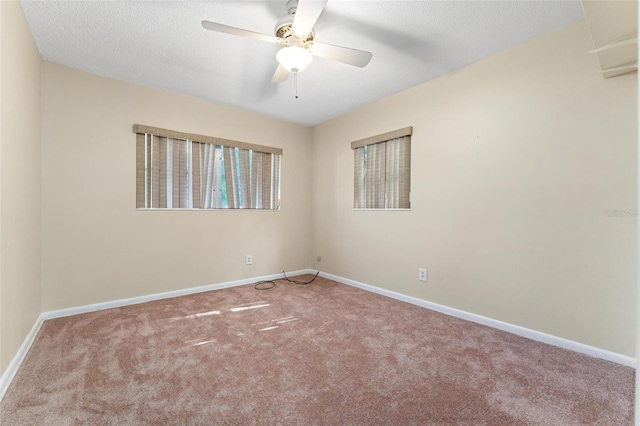 spare room with ceiling fan, a textured ceiling, and carpet