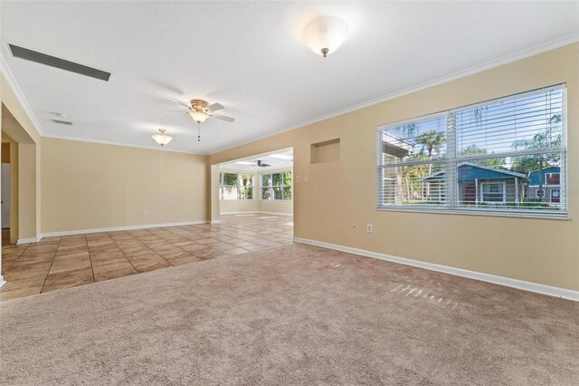 carpeted spare room featuring ceiling fan and crown molding