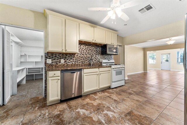 kitchen with light tile patterned floors, cream cabinetry, and stainless steel appliances