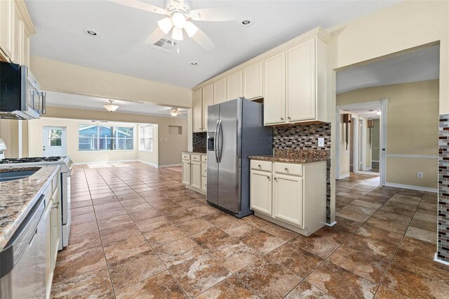 kitchen with ceiling fan, tasteful backsplash, tile patterned flooring, cream cabinets, and stainless steel appliances