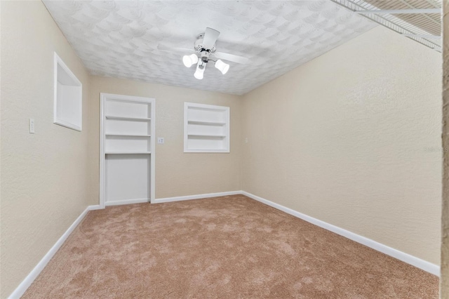 interior space with ceiling fan, built in features, and a textured ceiling