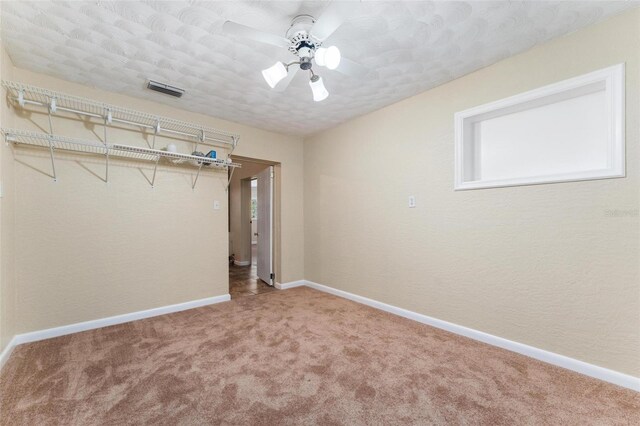 unfurnished bedroom featuring ceiling fan, a closet, a textured ceiling, and carpet