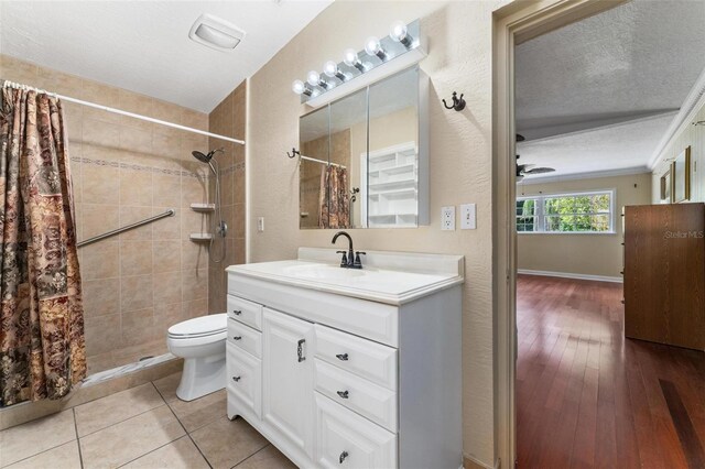 bathroom with toilet, vanity, hardwood / wood-style floors, curtained shower, and a textured ceiling