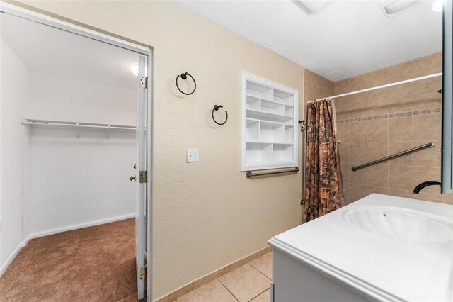 bathroom with curtained shower, built in shelves, tile patterned flooring, and vanity