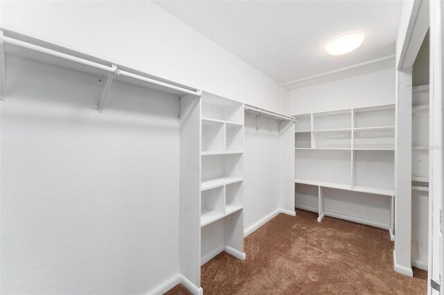 spacious closet featuring dark colored carpet