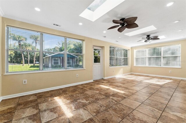 empty room featuring ceiling fan, a skylight, and tile patterned floors