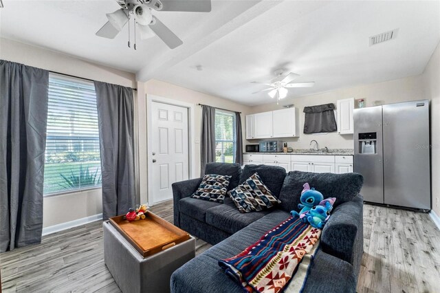 living room with sink, light hardwood / wood-style flooring, and ceiling fan