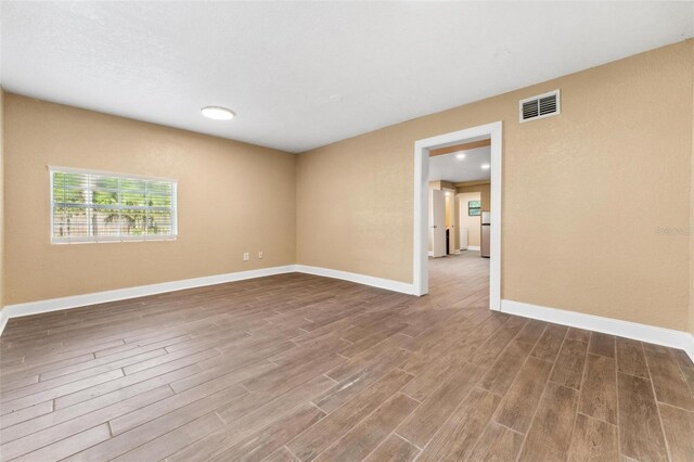 empty room with hardwood / wood-style flooring