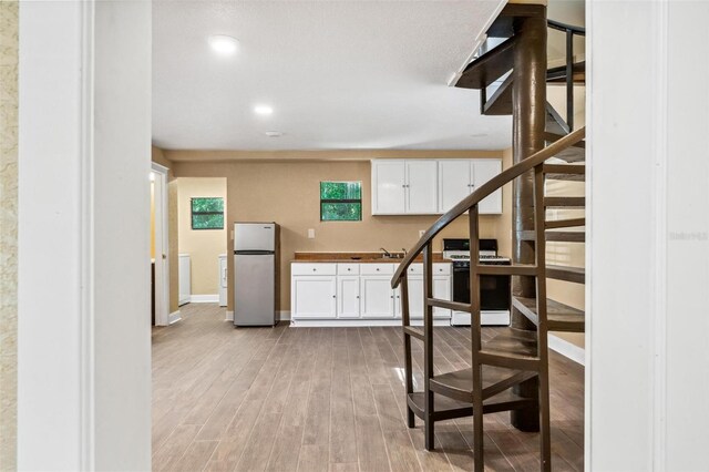 stairway with sink and hardwood / wood-style floors