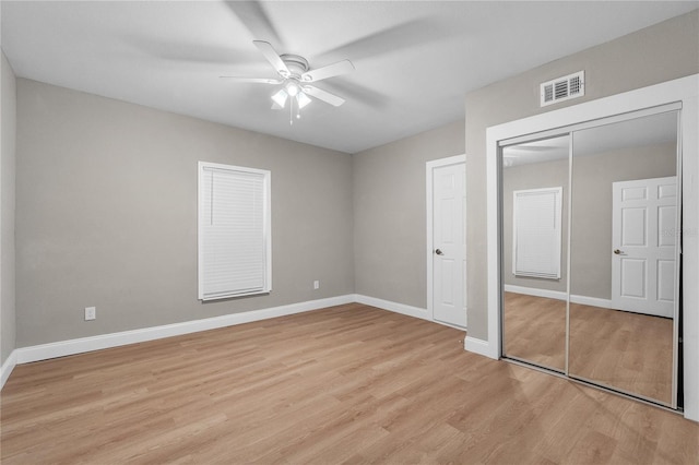 unfurnished bedroom featuring light wood-style flooring, a closet, visible vents, and baseboards