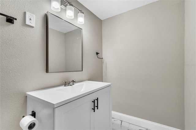 bathroom featuring marble finish floor, vanity, and baseboards