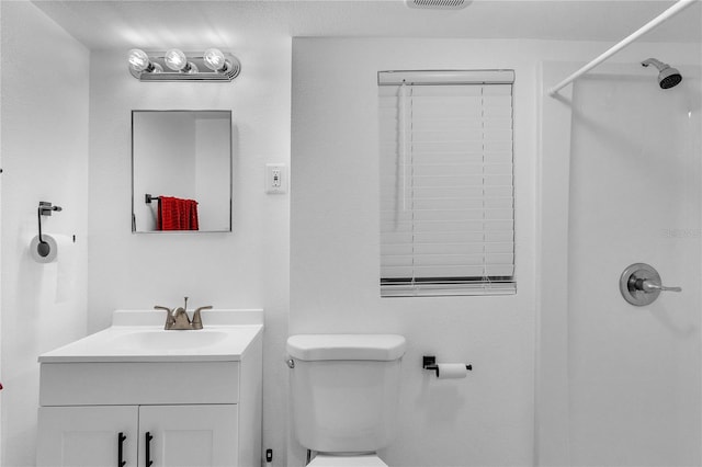 bathroom featuring toilet, visible vents, a shower, and vanity