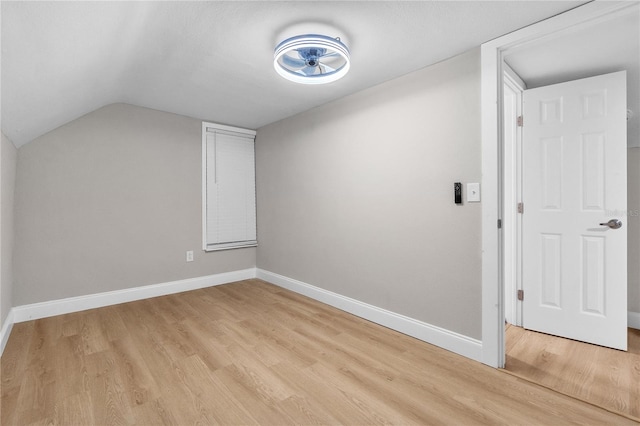 additional living space featuring light wood-type flooring and vaulted ceiling