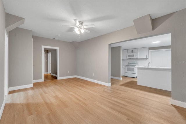 unfurnished living room with sink, light wood-type flooring, and ceiling fan