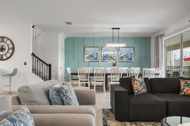 living room with light tile patterned floors and a chandelier