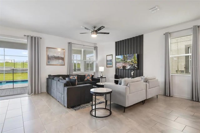 tiled living room featuring a wealth of natural light and ceiling fan