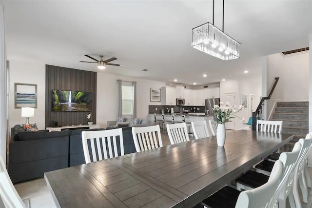 dining room featuring ceiling fan with notable chandelier