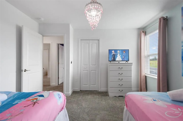 carpeted bedroom with a closet and a chandelier