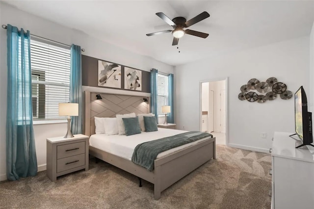 carpeted bedroom with ceiling fan, multiple windows, and ensuite bath