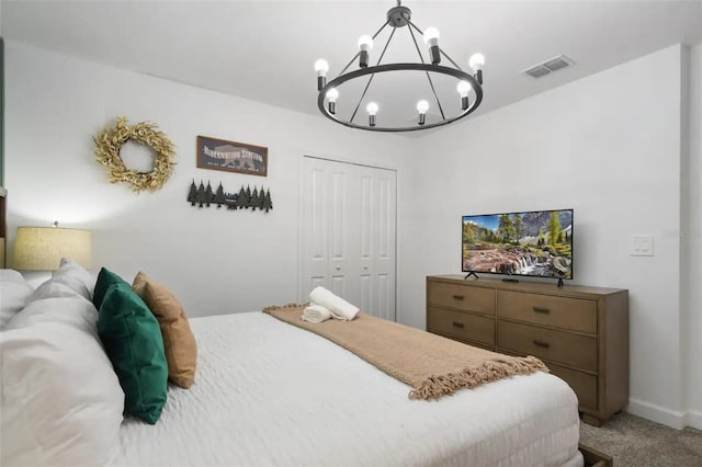 bedroom with a closet, a chandelier, and carpet flooring